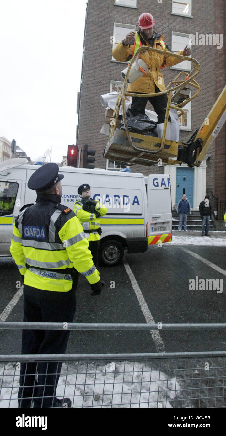 A man in a cherry picker covered with a number of slogans attacking politicians and the banking sector to protest outside the gates of Leinster House, Dublin, converses with gardai on Budget day. PRESS ASSOCIATION Photo. Picture date: Tuesday December 7, 2010. The demonstrator parked the crane near the Dail. The control panel was sealed off, preventing gardai from bringing the protester back to ground. See PA story IRISH Budget Protests. Photo credit should read: Niall Carson/PA Wire Stock Photo