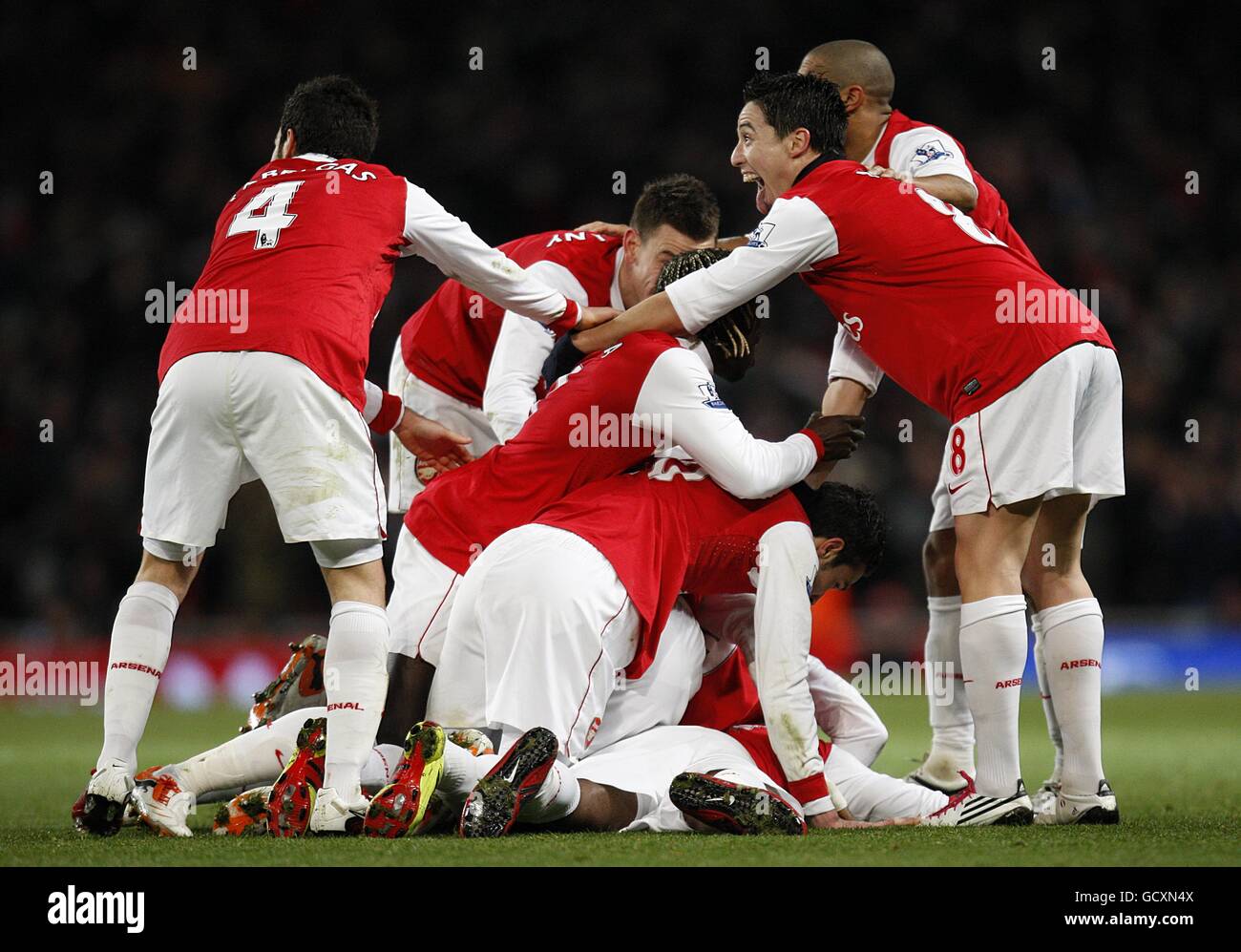 Arsenal's Alex Song (bottom of pile) celebrates with his team mates after scoring the opening goal of the game Stock Photo