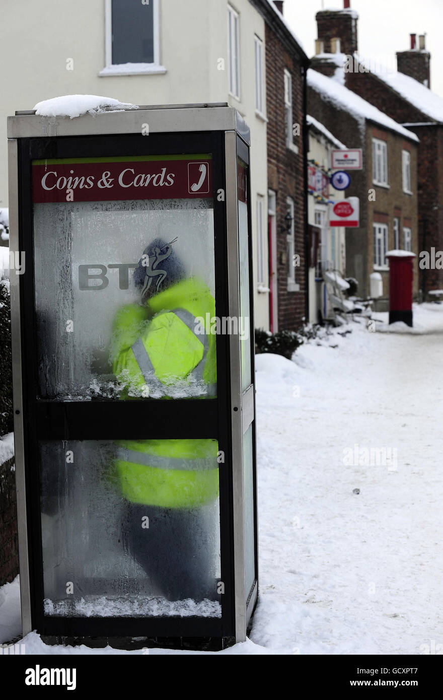 A man uses a telephone box in Topcliffe, near Thirsk in North Yorkshire. The village recorded a temperature of -19C earlier today, the coldest temperature recorded in Yorkshire since records began. Stock Photo