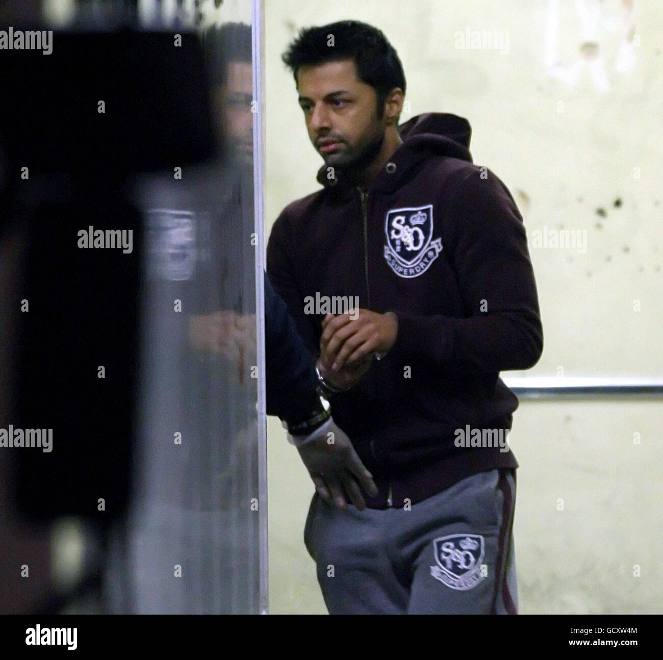 Shrien Dewani is escorted to a prison van as he leaves City of Westminster Magistrates Court, in Westminster, London. The British newlywed, accused of hiring a hitman to murder his bride, was remanded in custody tonight as the South African authorities fought to extradite him. Stock Photo