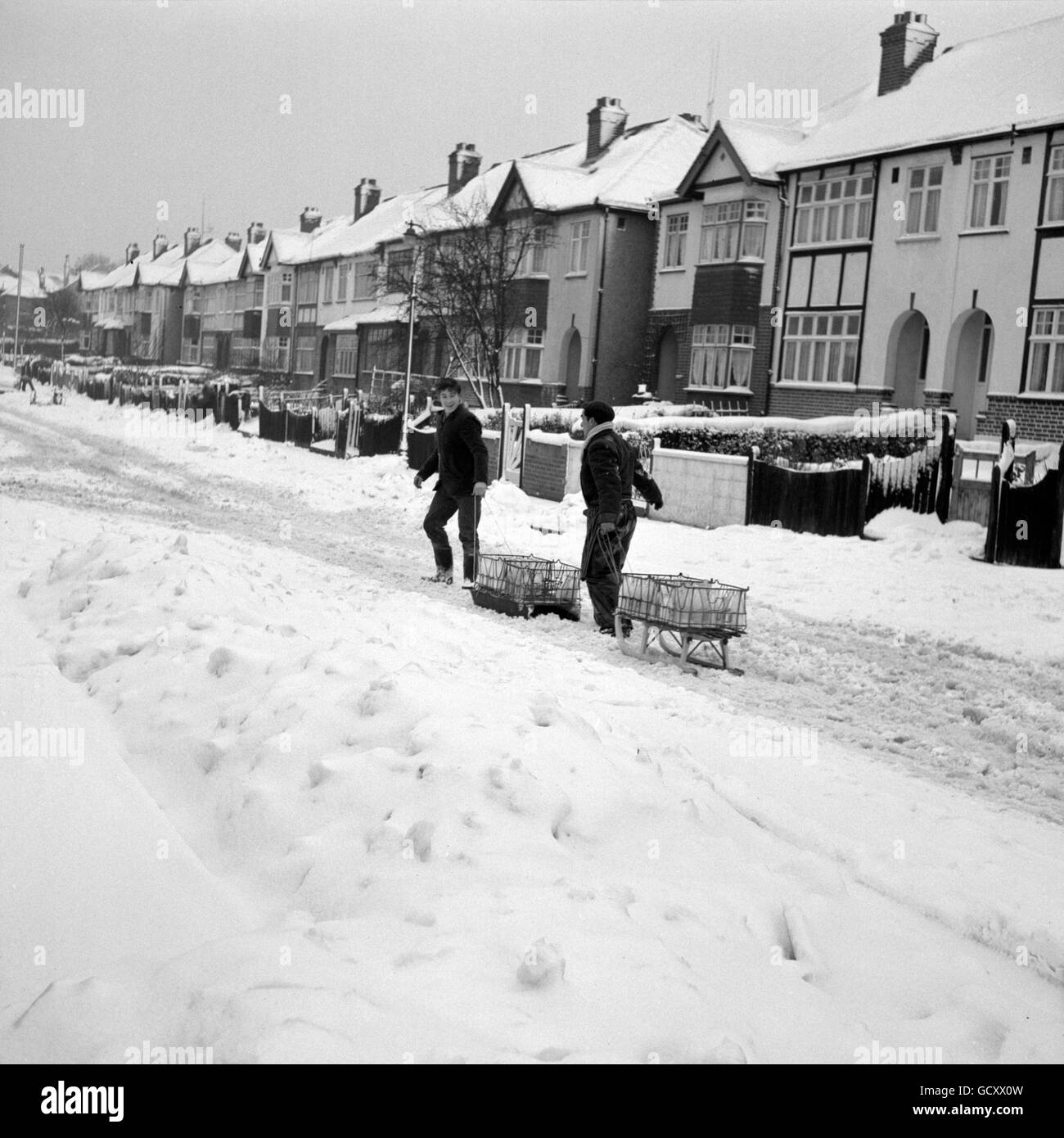 The milk roundsmen of South London, utilising children's sledges to make their deliveries in the snow at Forest Hill. Stock Photo