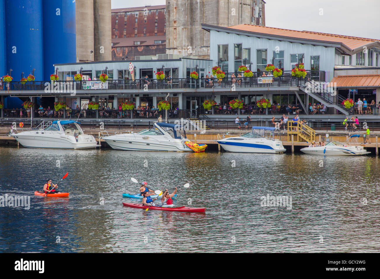 People kayaking past Buffalo Riverworks complex in the Buffalo River in
