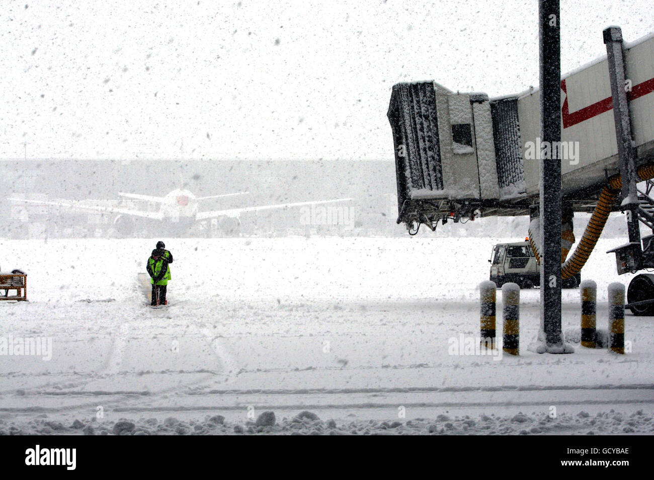 Workers try to clear the snow at Heathrow Airport, after all flights at the airport were grounded. Stock Photo