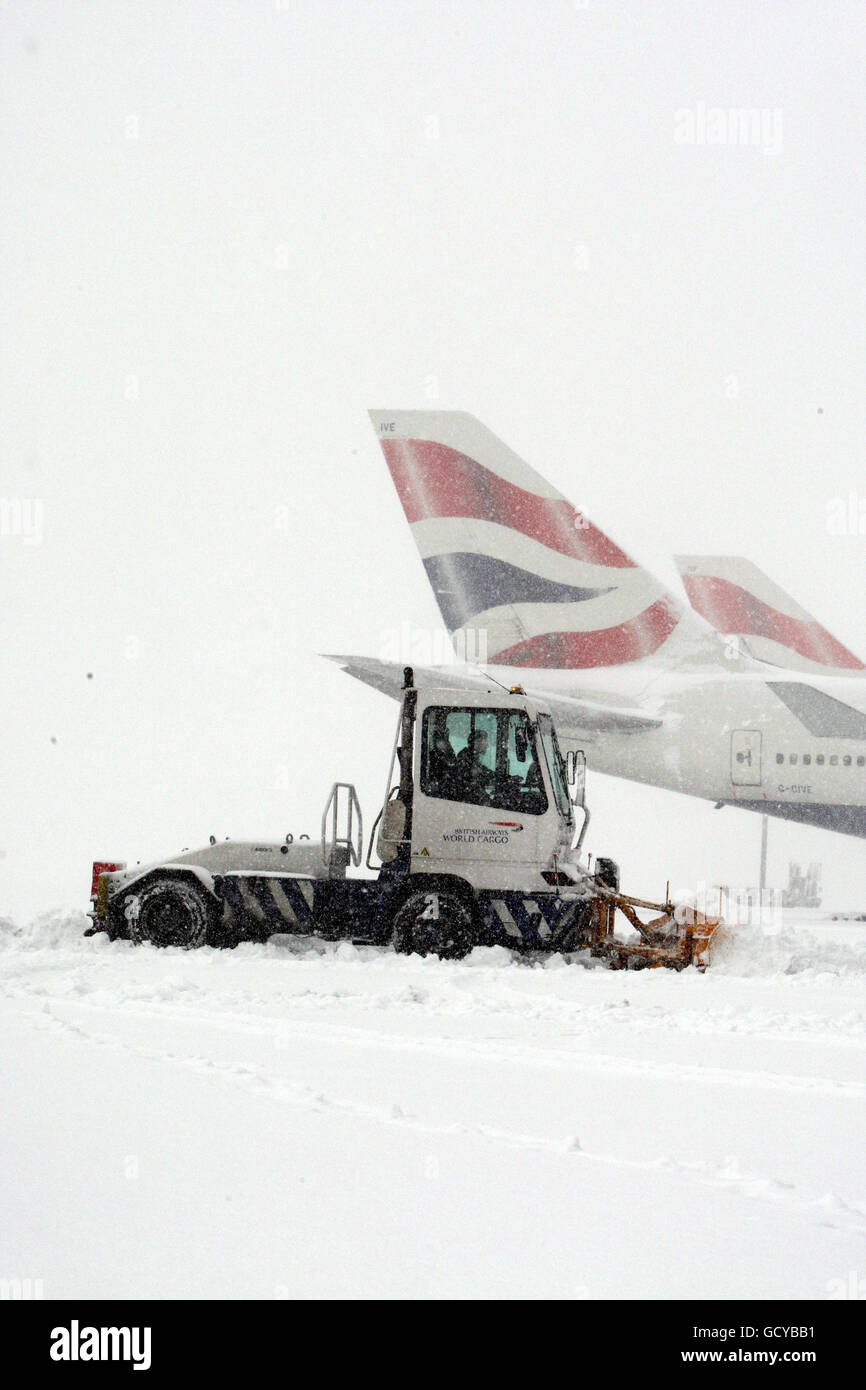 Workers try to clear the snow at Heathrow Airport, after all flights at the airport were grounded. Stock Photo