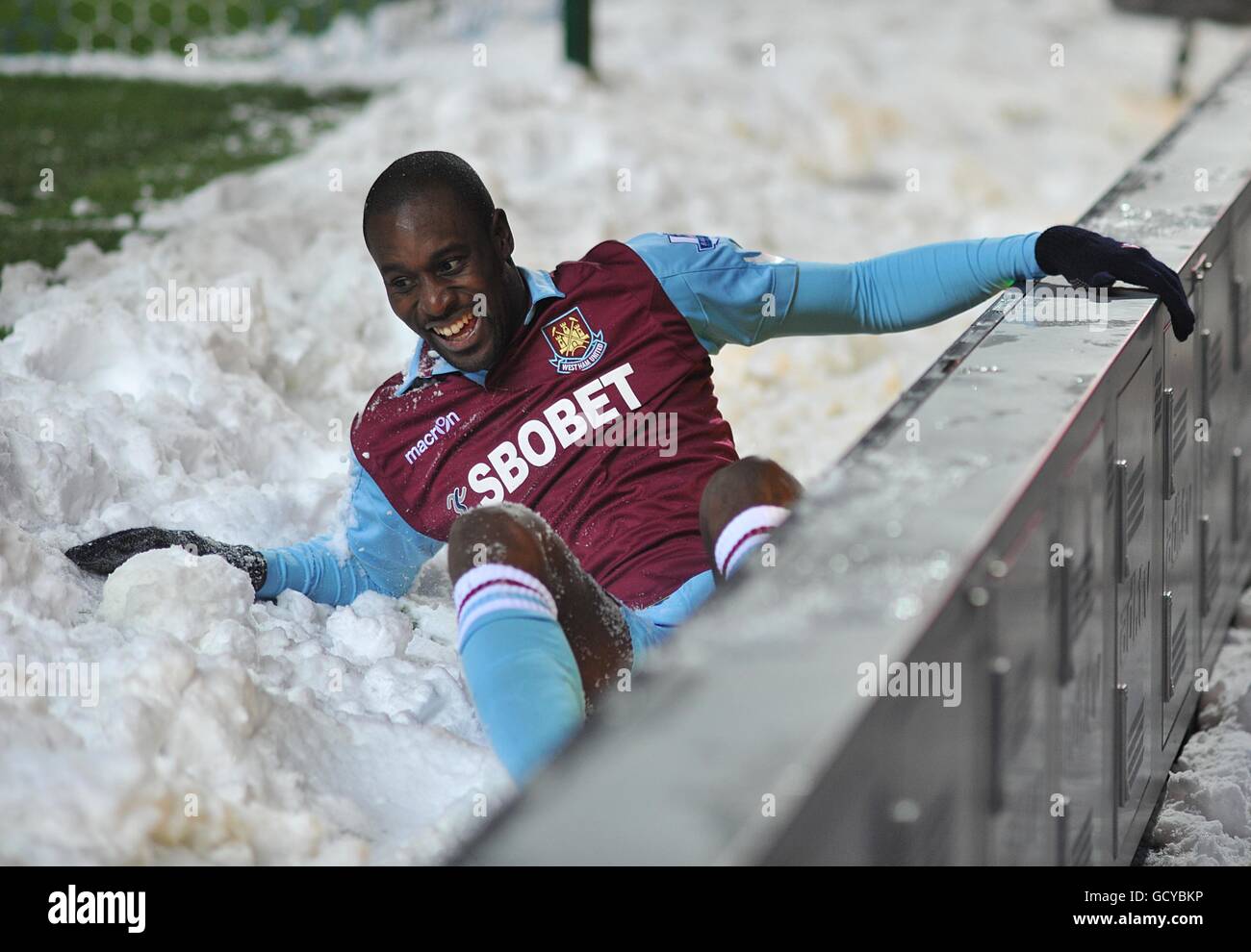 West Ham United's Carlton Cole falls into the snow during the match Stock Photo