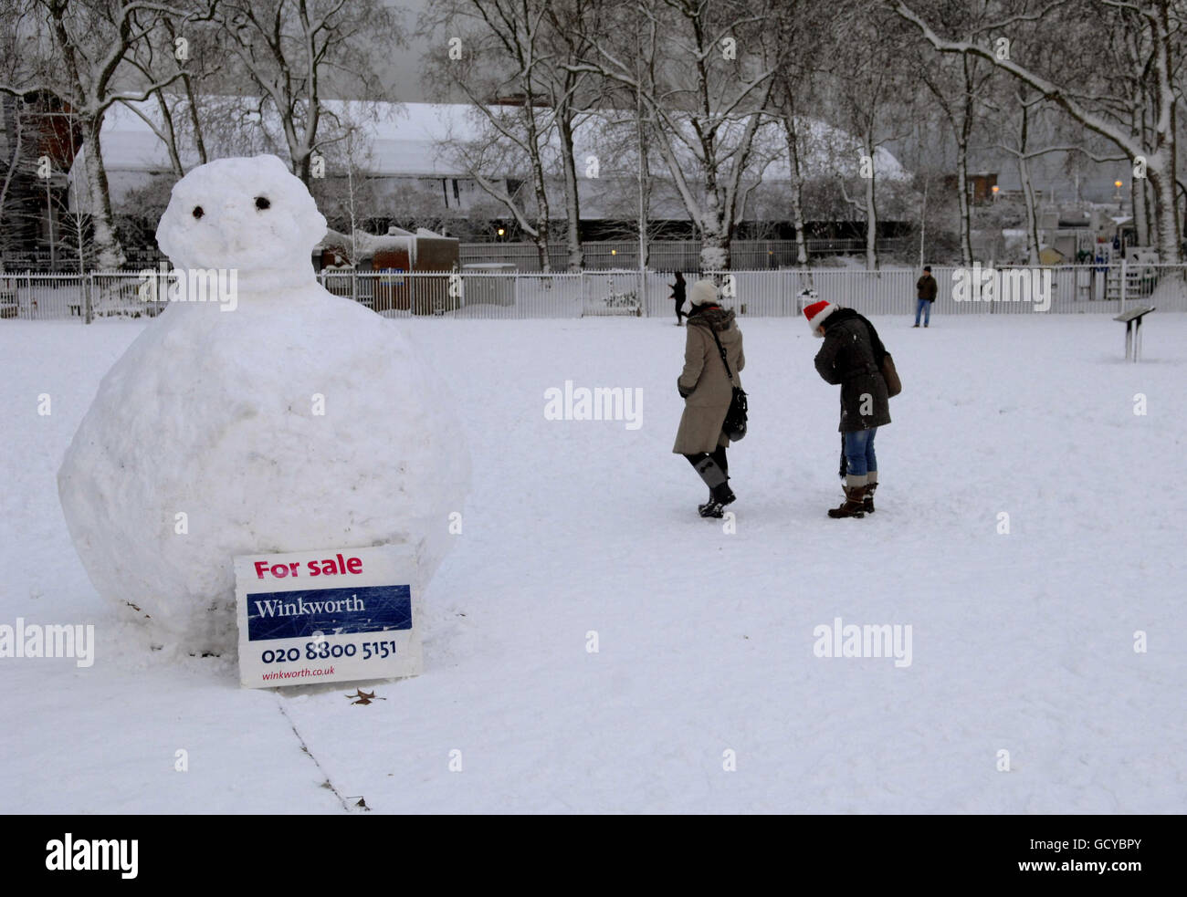 A snowman has a for sale sign placed below it in Finsbury Park, north London, after heavy snowfall across the capital. Stock Photo