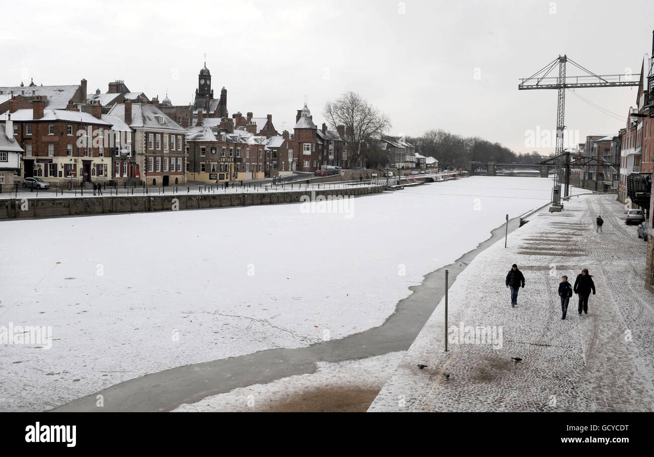 People walk past the River Ouse in the City of York, which froze over night. Stock Photo