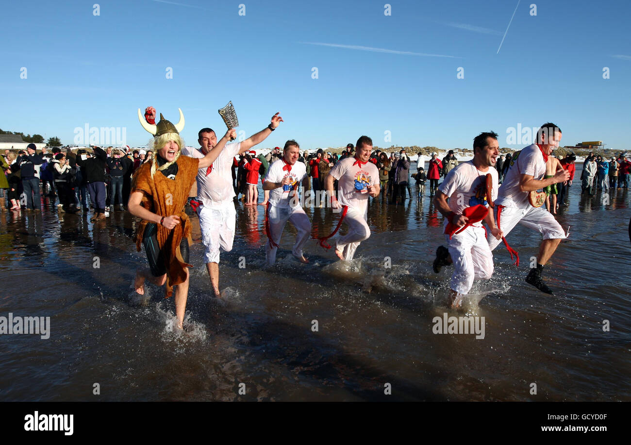 Christmas 2010. Christmas day revellers enjoy the annual Porthcawl Charity swim in the resorts Coney Beach. Stock Photo