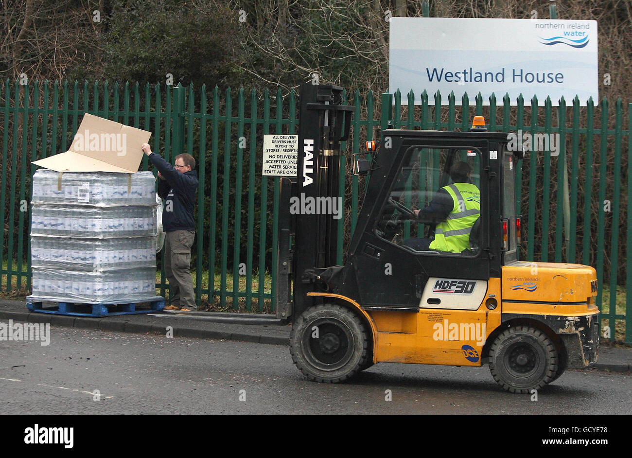 An employee of Northern Ireland Water drops off a pallet of drinking water supplied by the Scottish Executive outside the company's headquarters in North Belfast. Stock Photo