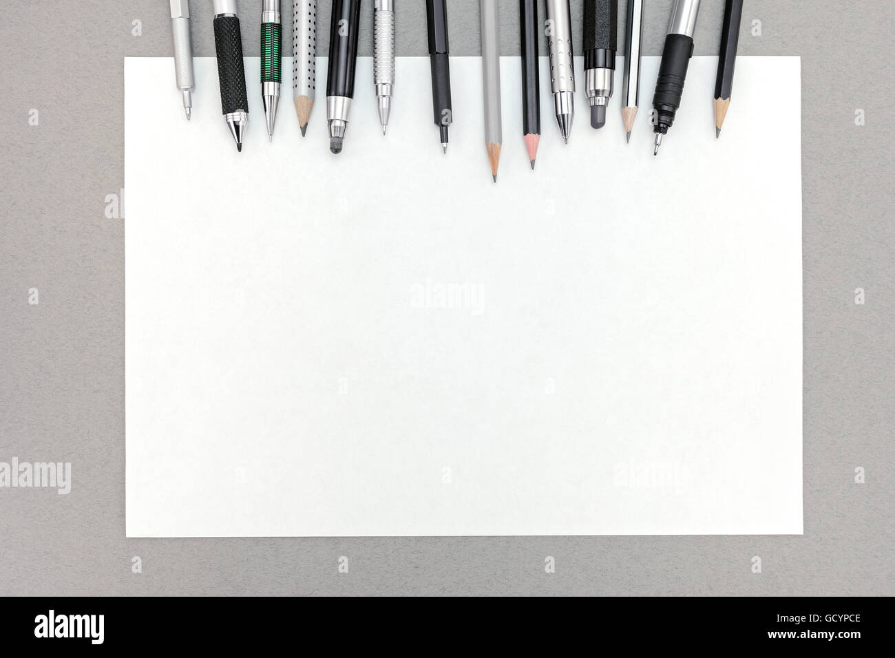 office desk table with blank sheet of paper and various drawing tools