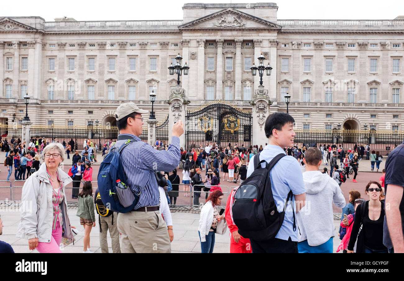 Tourists taking photographs outside Buckingham Palace London UK Stock Photo