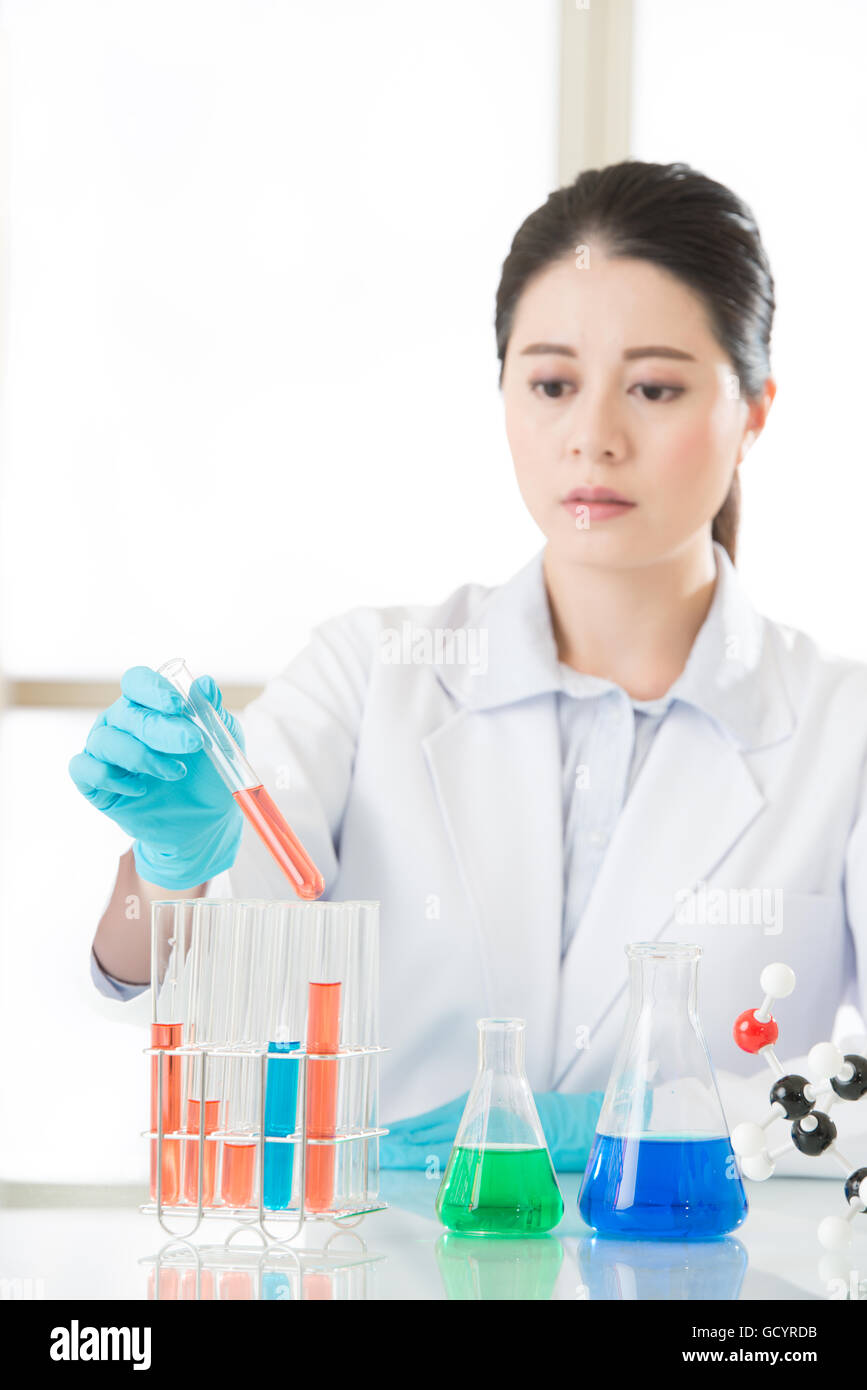 Beautiful Asian female biologist working on chemicals in laboratory Stock Photo