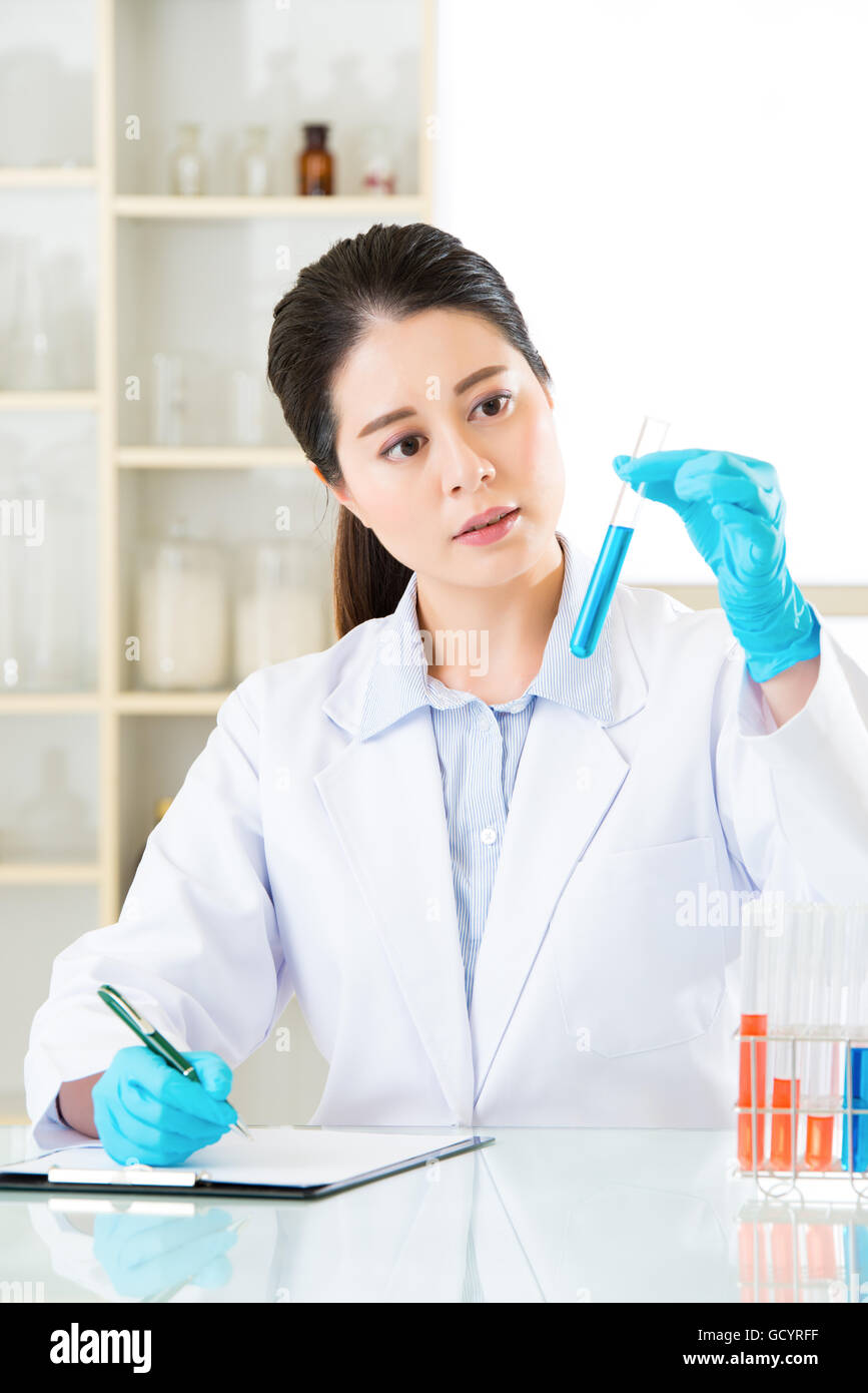 Asian female scientist recording her research data write on clipboard