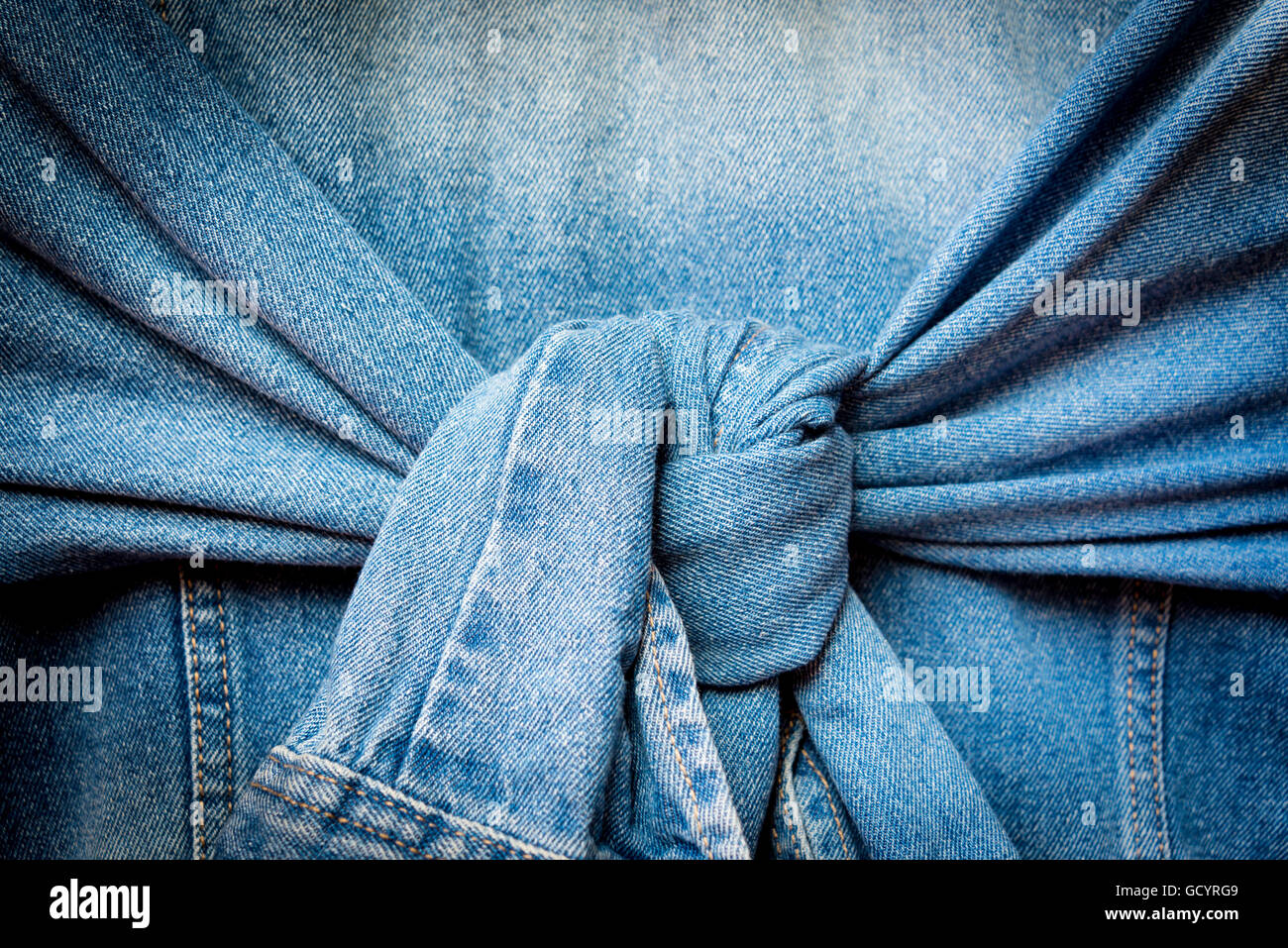 Blue denim jacket with knot tied sleeves Stock Photo