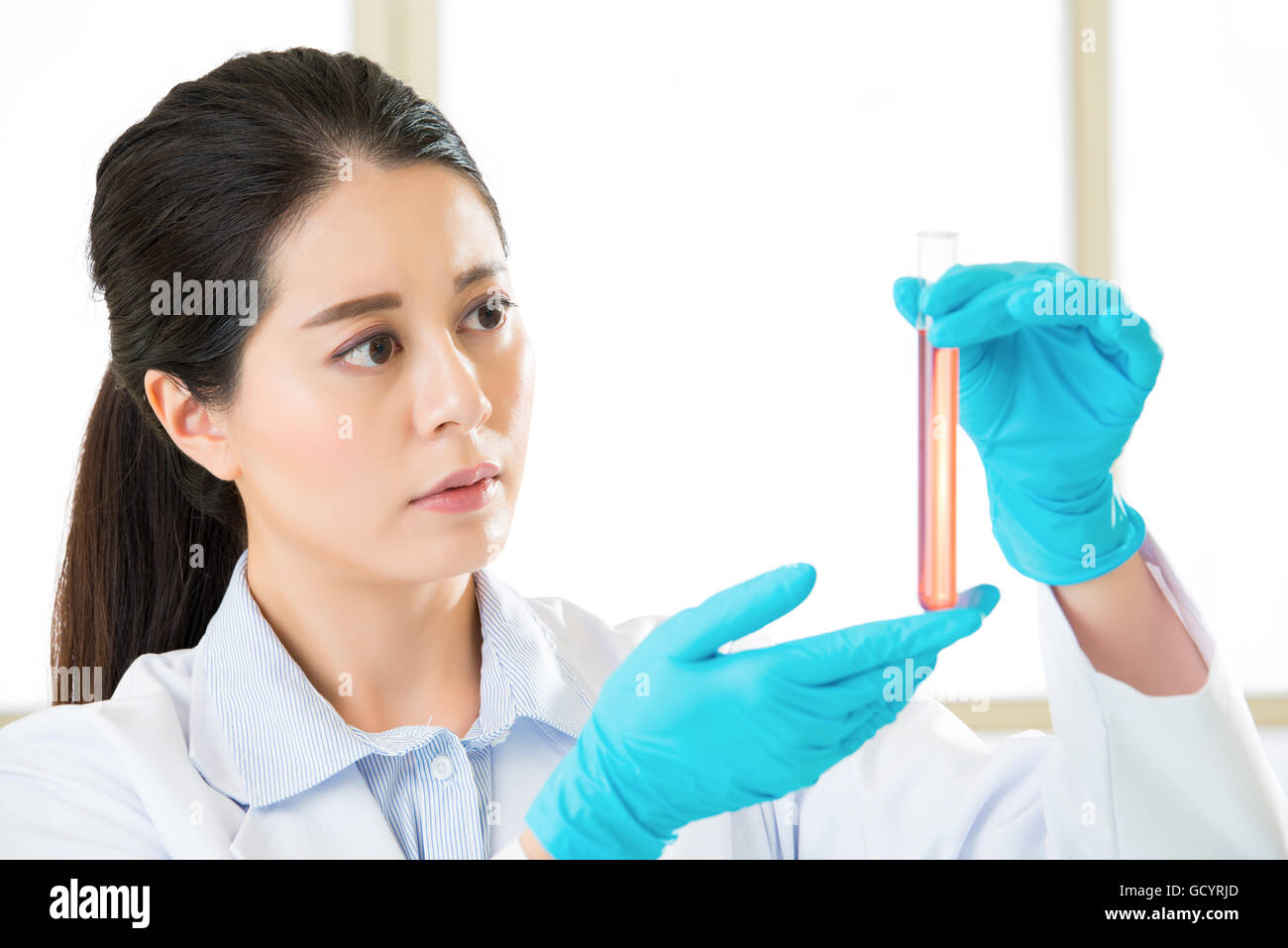 Beautiful biologist pipetting in life science laboratory with gloves Stock Photo