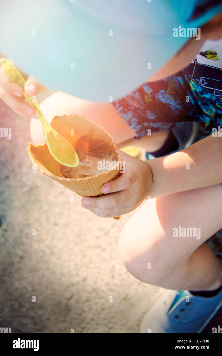 Little boy eating a cone with chocolate ice cream Stock Photo
