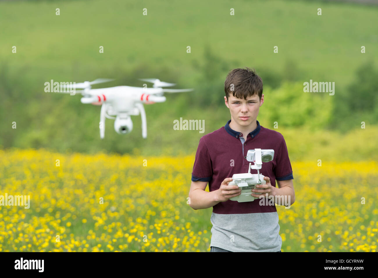 Teenage boy operating a quadcopter drone in countryside, UK. Stock Photo