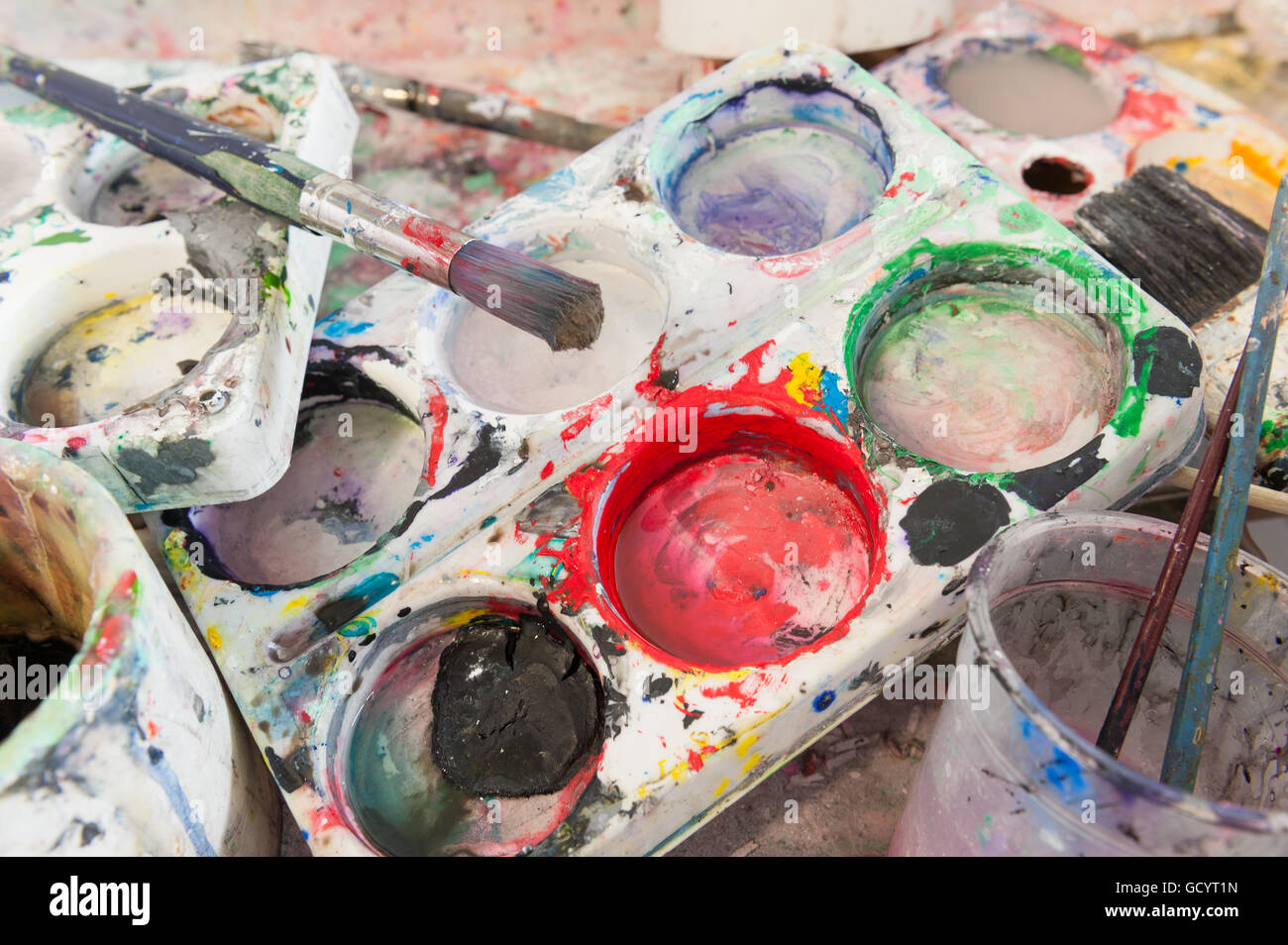 discarded left behind dirty paint brushes in butlers sink needing a serious clean and polish after messy art students painters Stock Photo