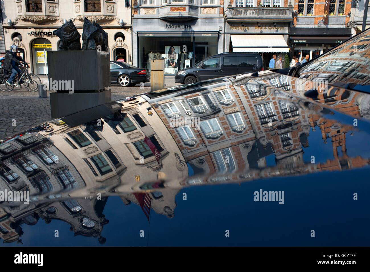 Reflection in a car. Shops and buildings in IJzerenleen street, Mechelen (Malines) at sunset, Flanders, Belgium. Stock Photo