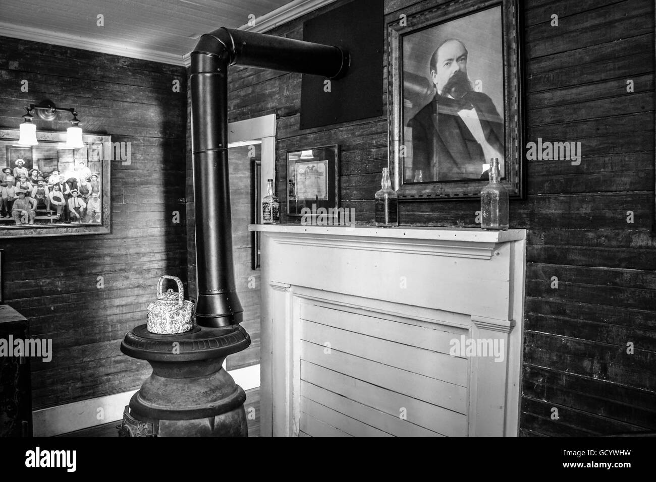 A photo of Jack Daniel hangs over the mantel & pot bellied stove in the interior of the preserved antique Distillery Office in Lynchburg, TN, USA Stock Photo