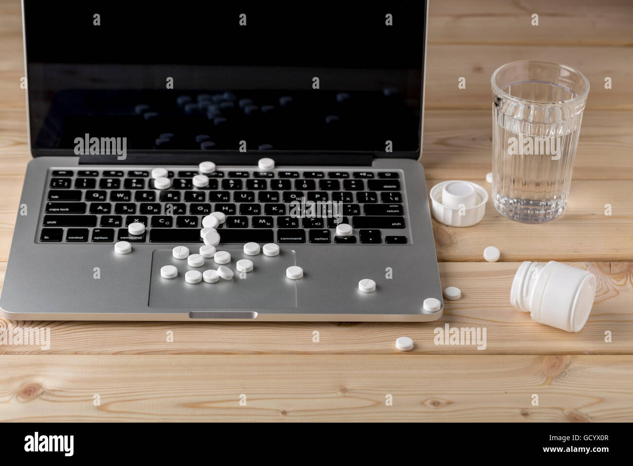 Heap of round white pills on the open pc notebook Stock Photo