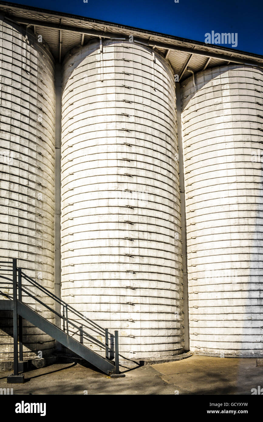 Tall white silo like grain mills stand as Abstract structures Stock Photo