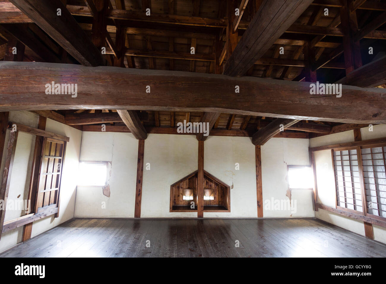 Japan, Matsuyama, Iyo Matsuyama castle. Yagura, turret, interior showing double shooting, gun ports and huge wooden beams supporting the ceiling. Stock Photo