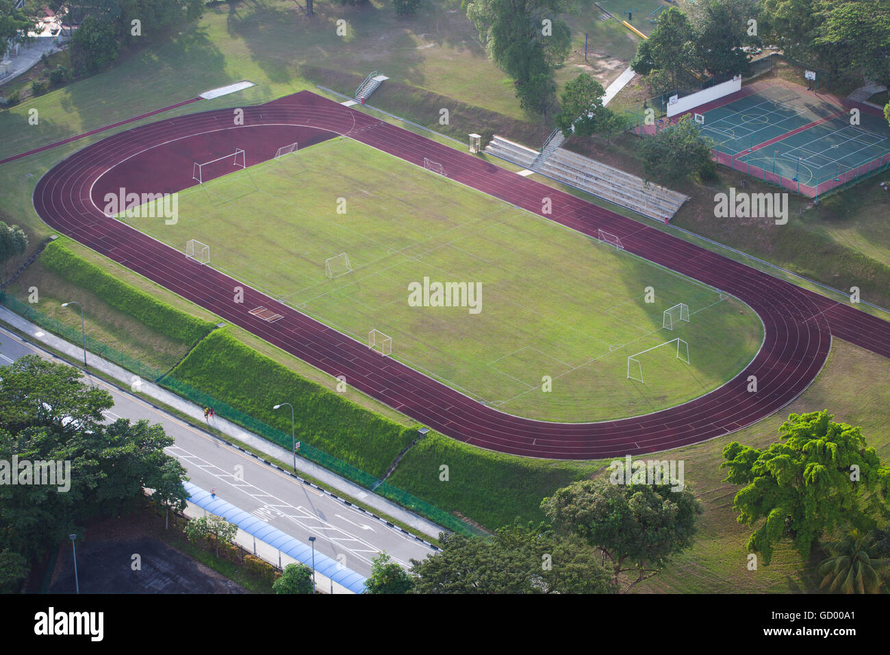 Aerial view of a school football field, two tennis court and 