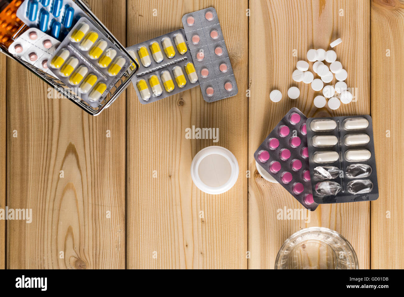 Heap of medicine colorful pills blister pack and water glass Stock Photo