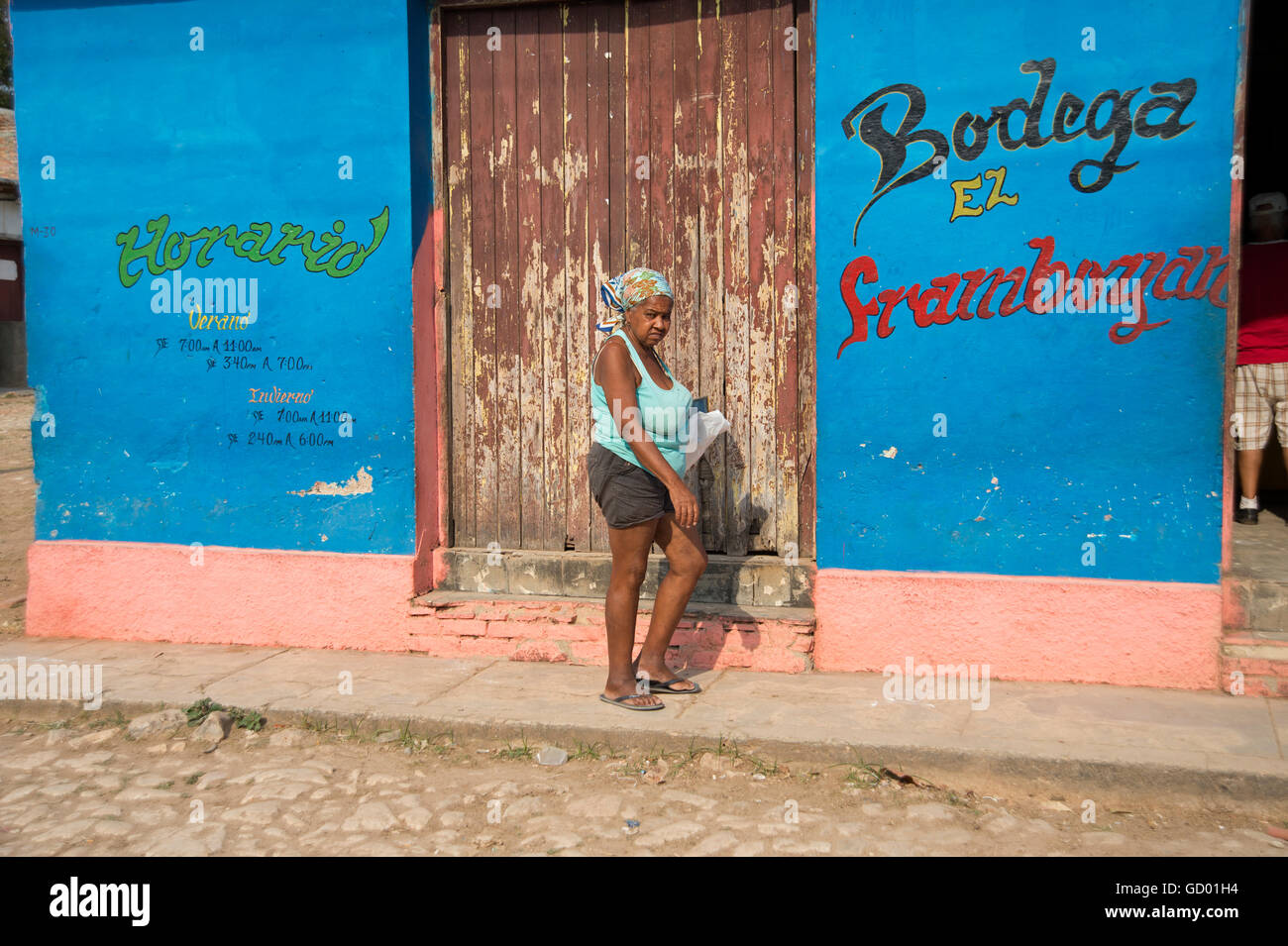 An old Cuban woman walking along the cobbled streets of Trinidad towards a Bodega in Cuba Stock Photo