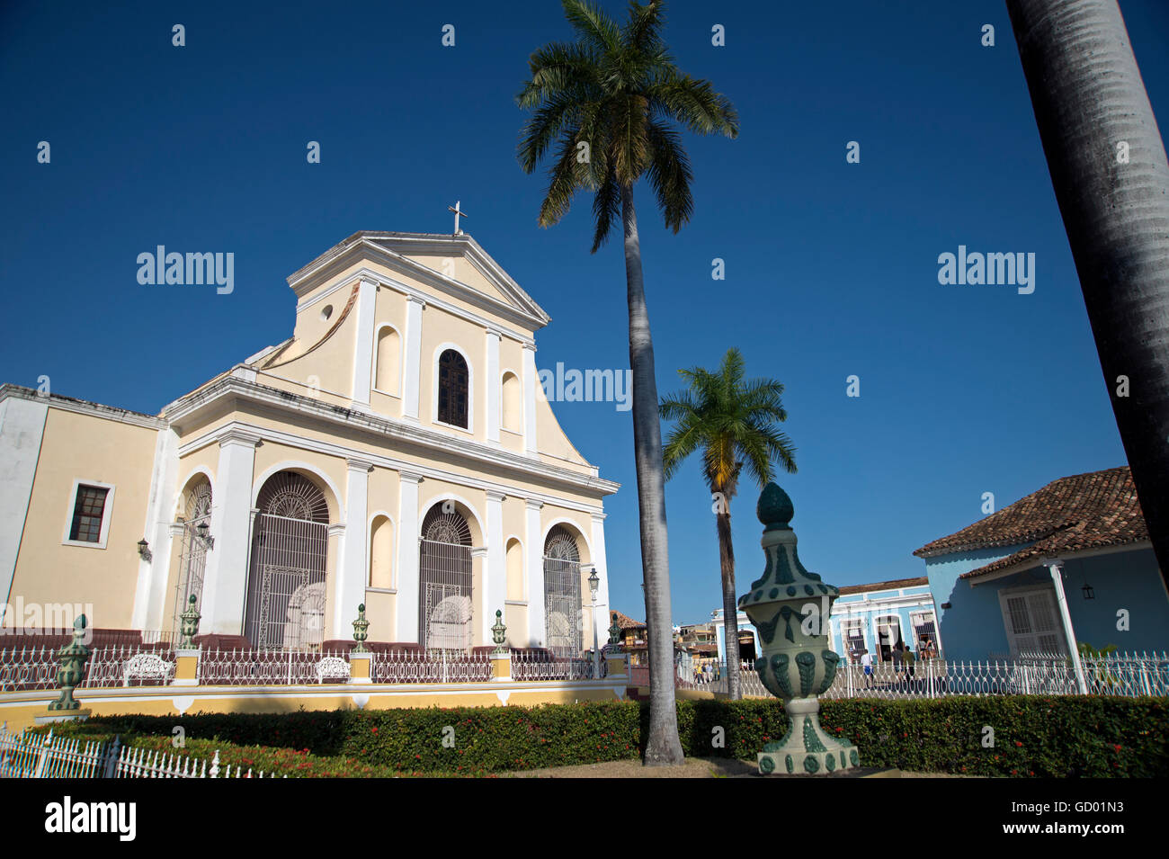 A view of the Iglesia Parroquial de la Santisima church with blue sky and palm trees in the Plaza Mayar Trinidad Cuba Stock Photo
