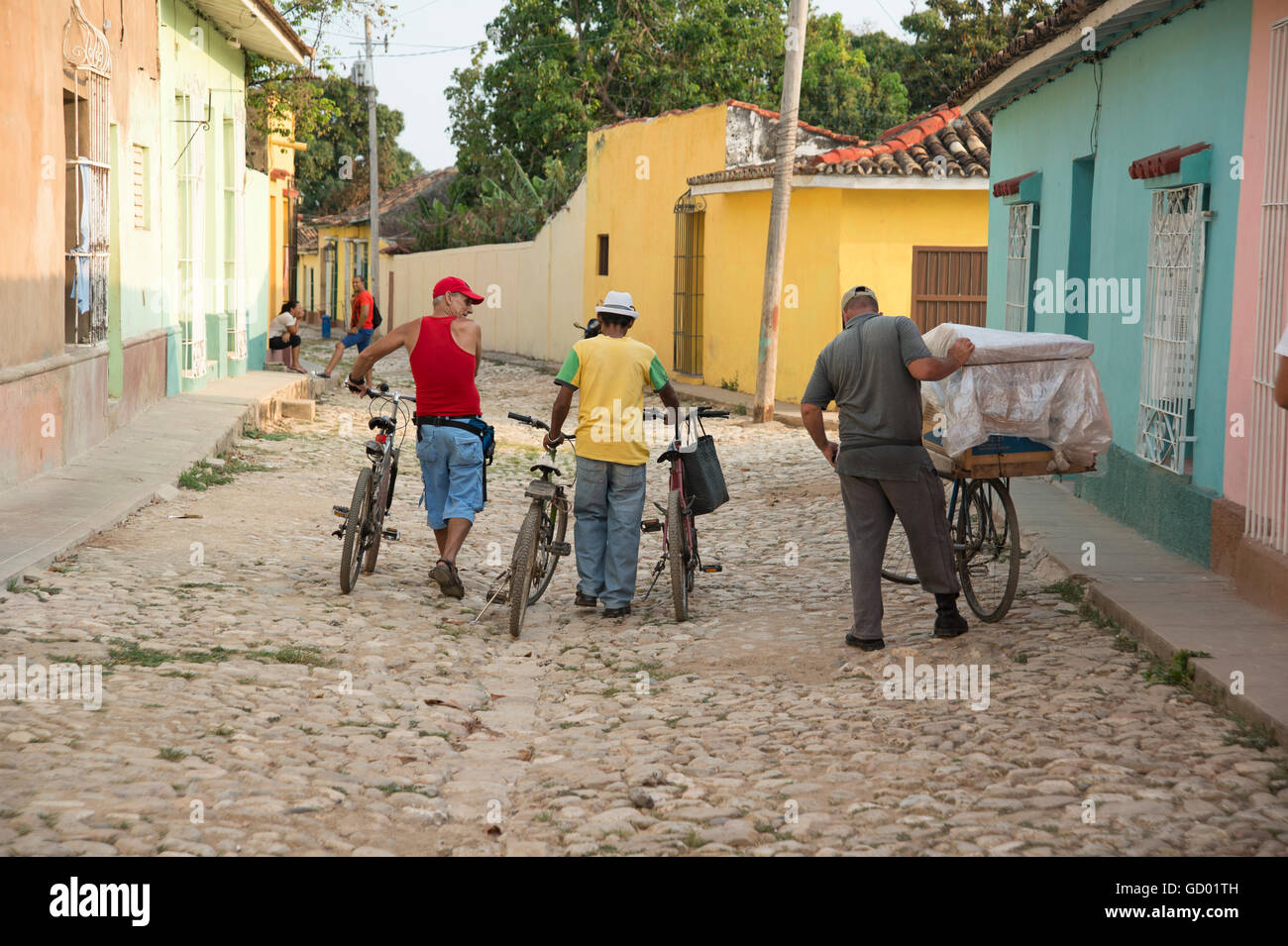 Local Cuban men walking their bicycles through the cobbled streets of ...