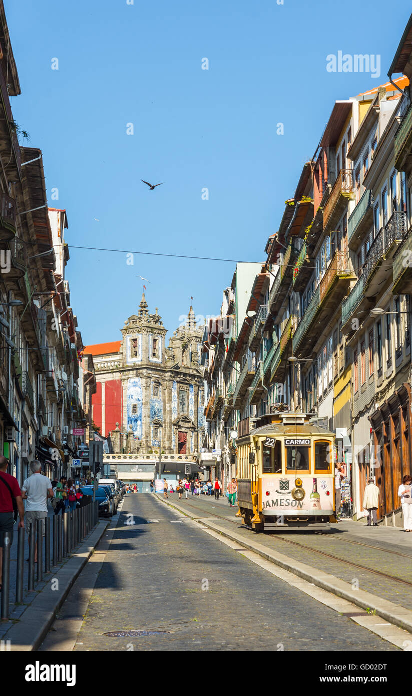Tram crossing Rua 31 de Janeiro street with Igreja de Santo Ildefonso church in background. Porto. Portugal. Stock Photo