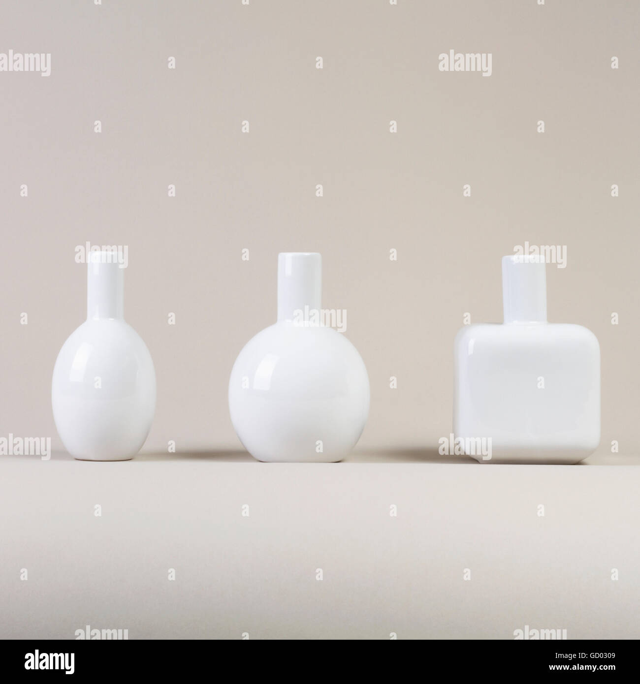 Small white vases set different shapes on gray background side view Stock Photo