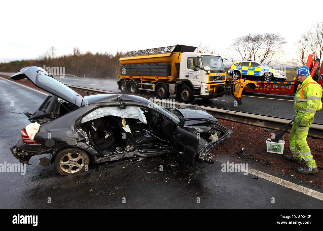 Scottish motorway crash. A gritter passes a wrecked car after four vehicles crashed on the M9 motorway near Stirling. Stock Photo
