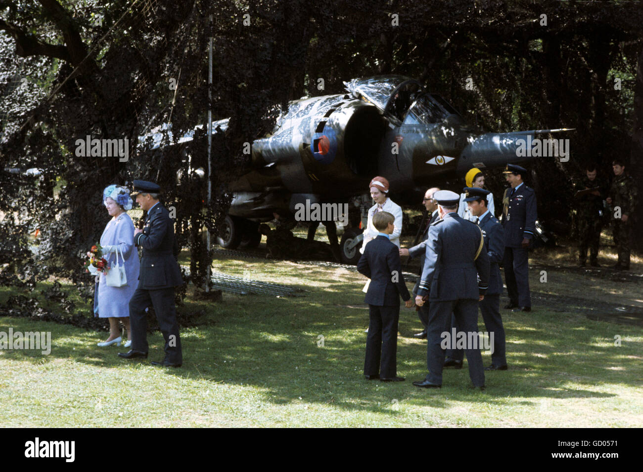 The Queen Mother, Prince Charles, Prince Edward and Princess Alexandra take part in the Queen's Silver Jubilee review of the Royal Air Force at RAF Finningley. Behind is one of the RAF's Harrier jump jets among the trees Stock Photo