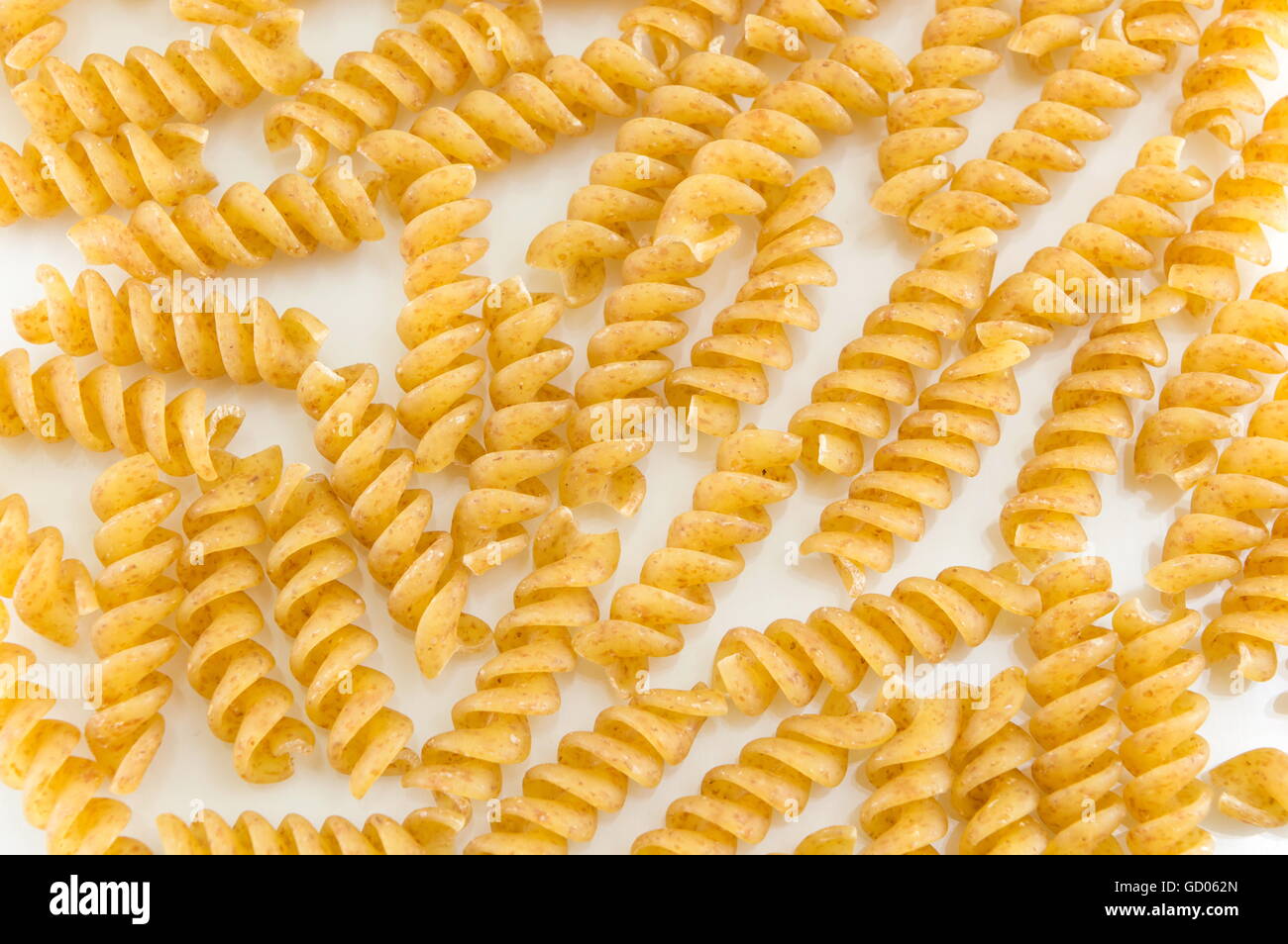 Bunch of golden colored macaroni pasta on a table Stock Photo