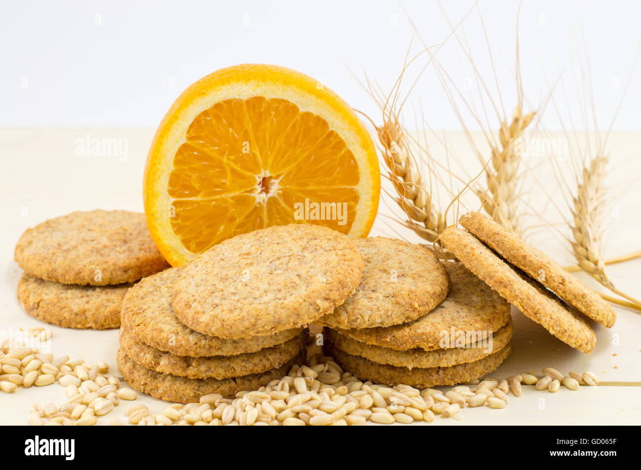 Integral biscuits with orange and wheat seeds on white background Stock Photo