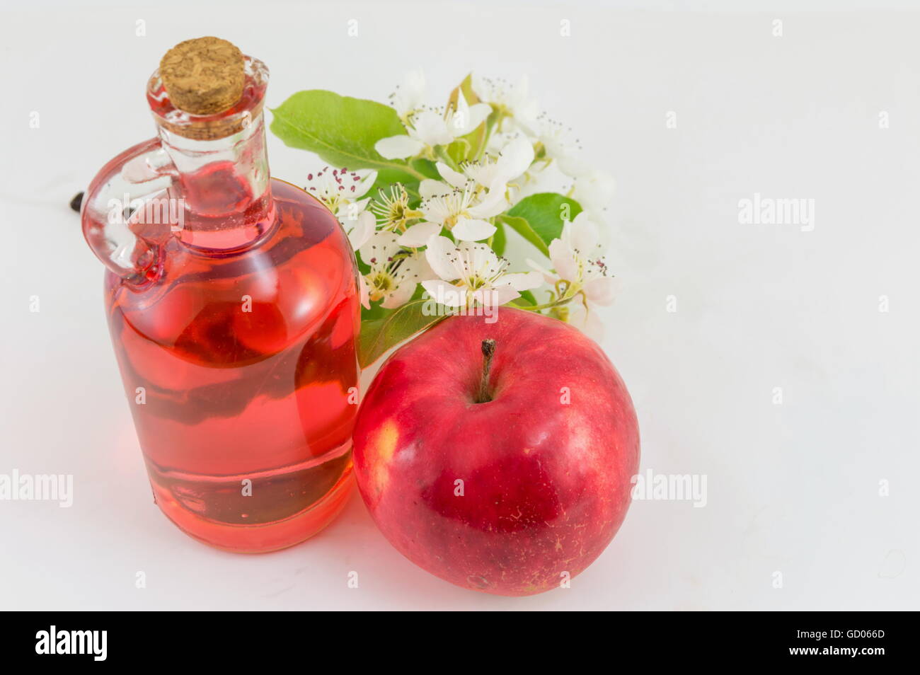 Red apple and apple vinegar decorated with flowers Stock Photo