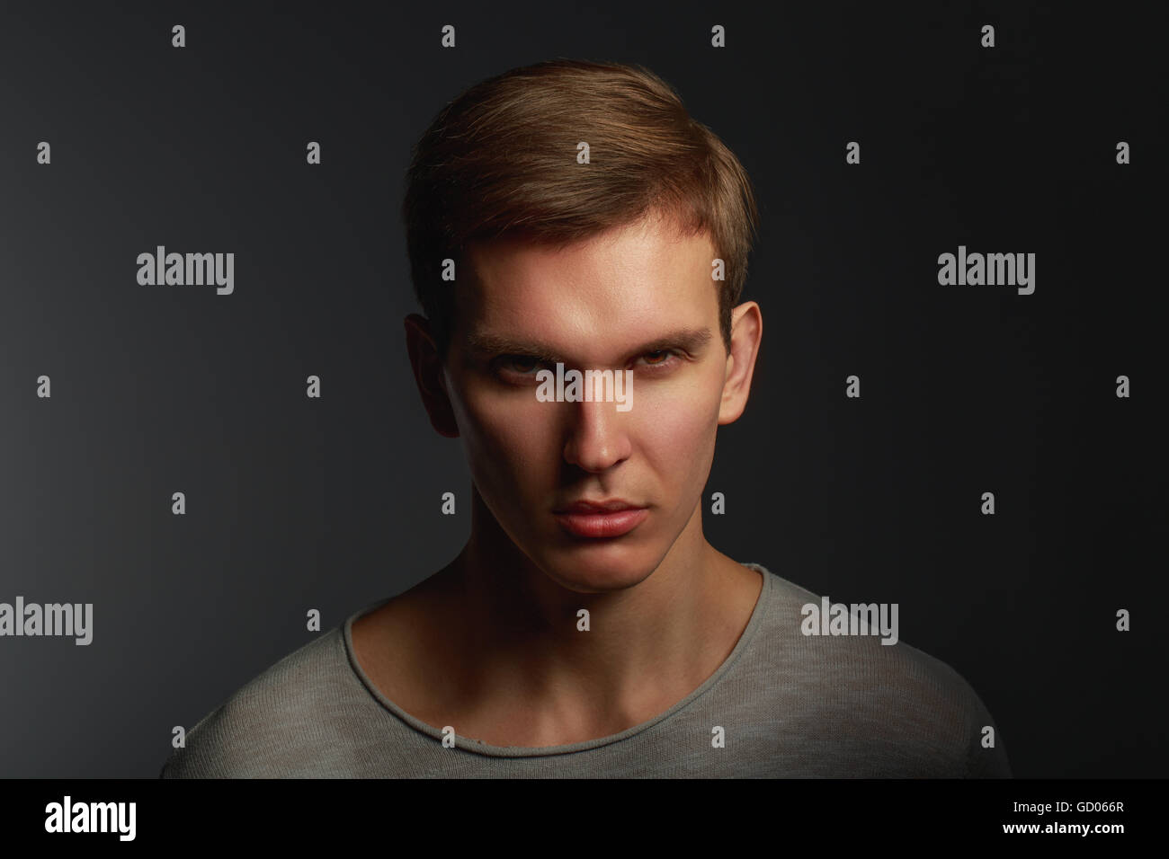 Dark fashion portrait of young angry man with contrast shadows Stock Photo