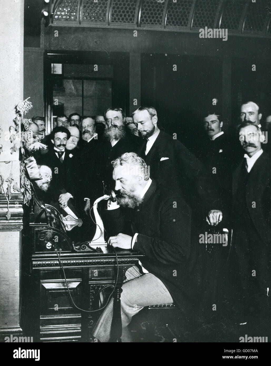 Photo of Alexander Graham Bell, inventor of the telephone,  talking into an early-style telephone at the opening of the New York-Chicago line. Stock Photo