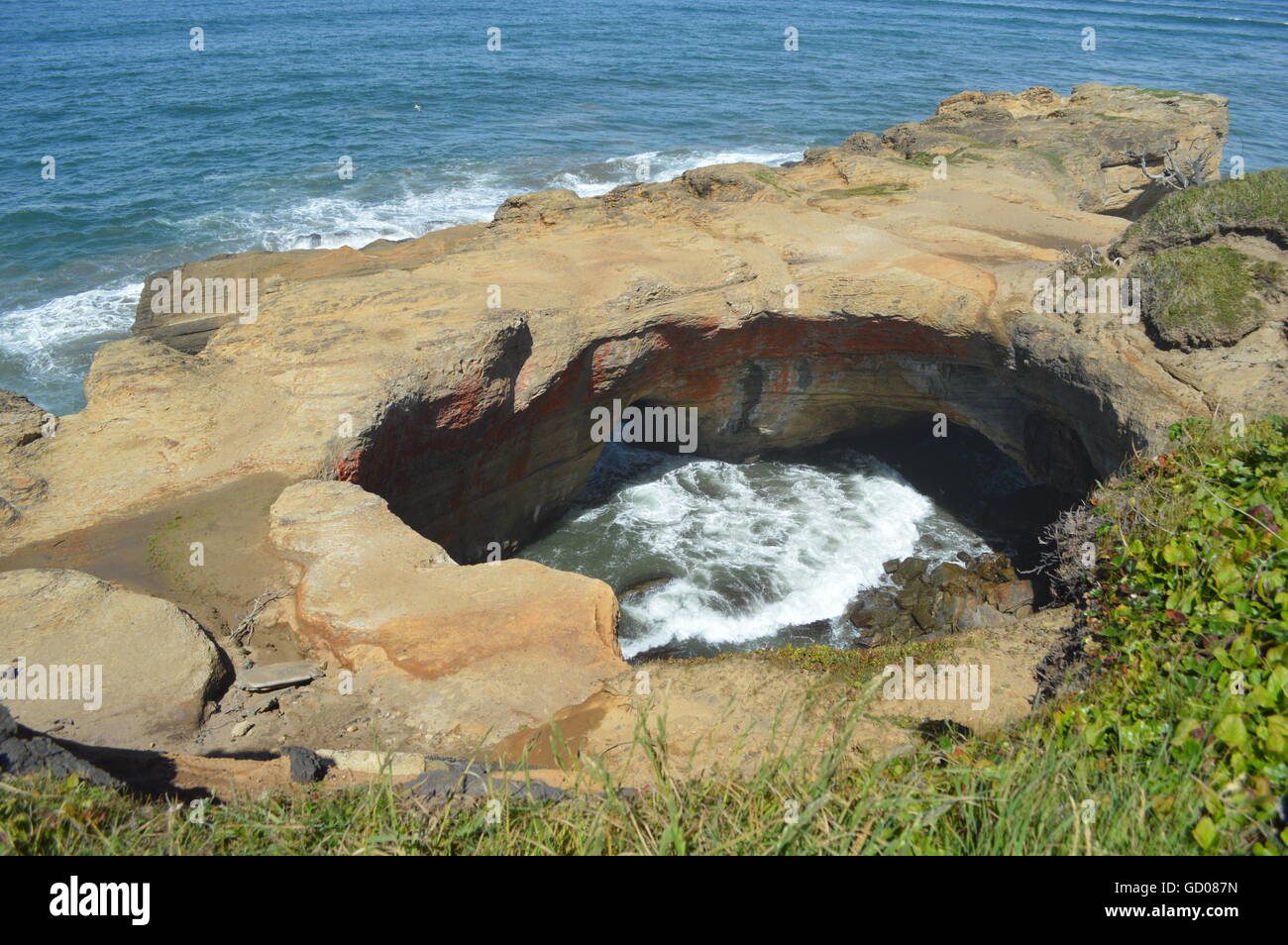 The Devil's Punch Bowl near Newport Oregon as the waves roll in through the two sea caves. Stock Photo