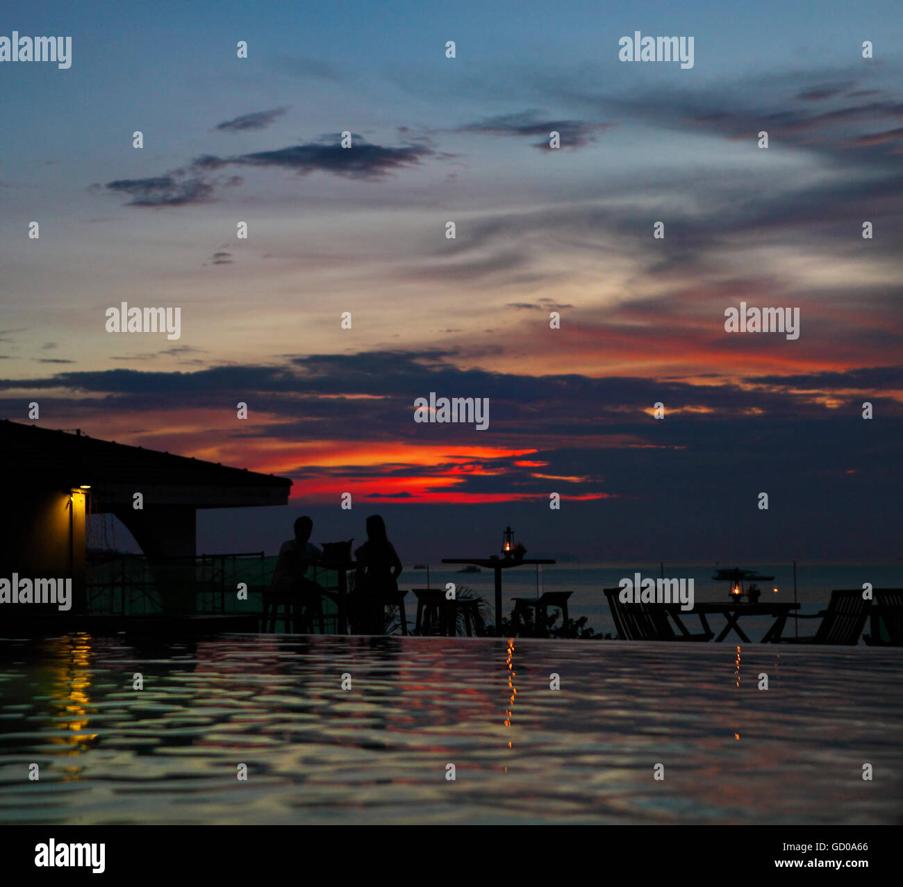 The silhouette of couple watching sunset in the beach cafe Stock Photo ...