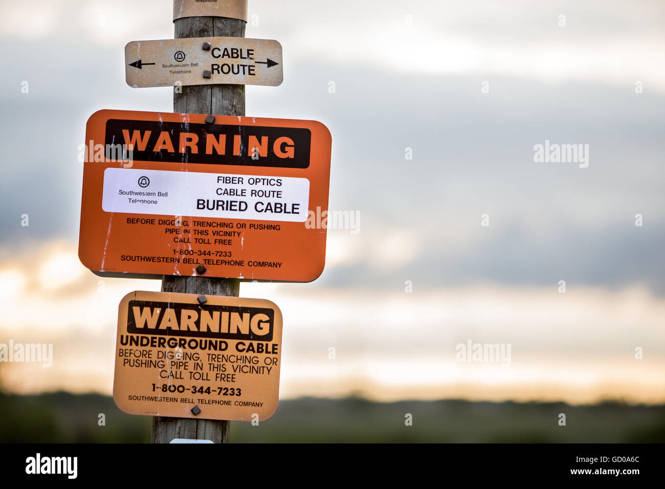 Sign warning that fiber optic cable is buried below. Stock Photo