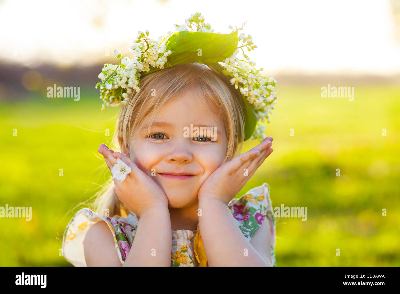 Cute little girl with blond hair in a wreath of lily of the valley in ...