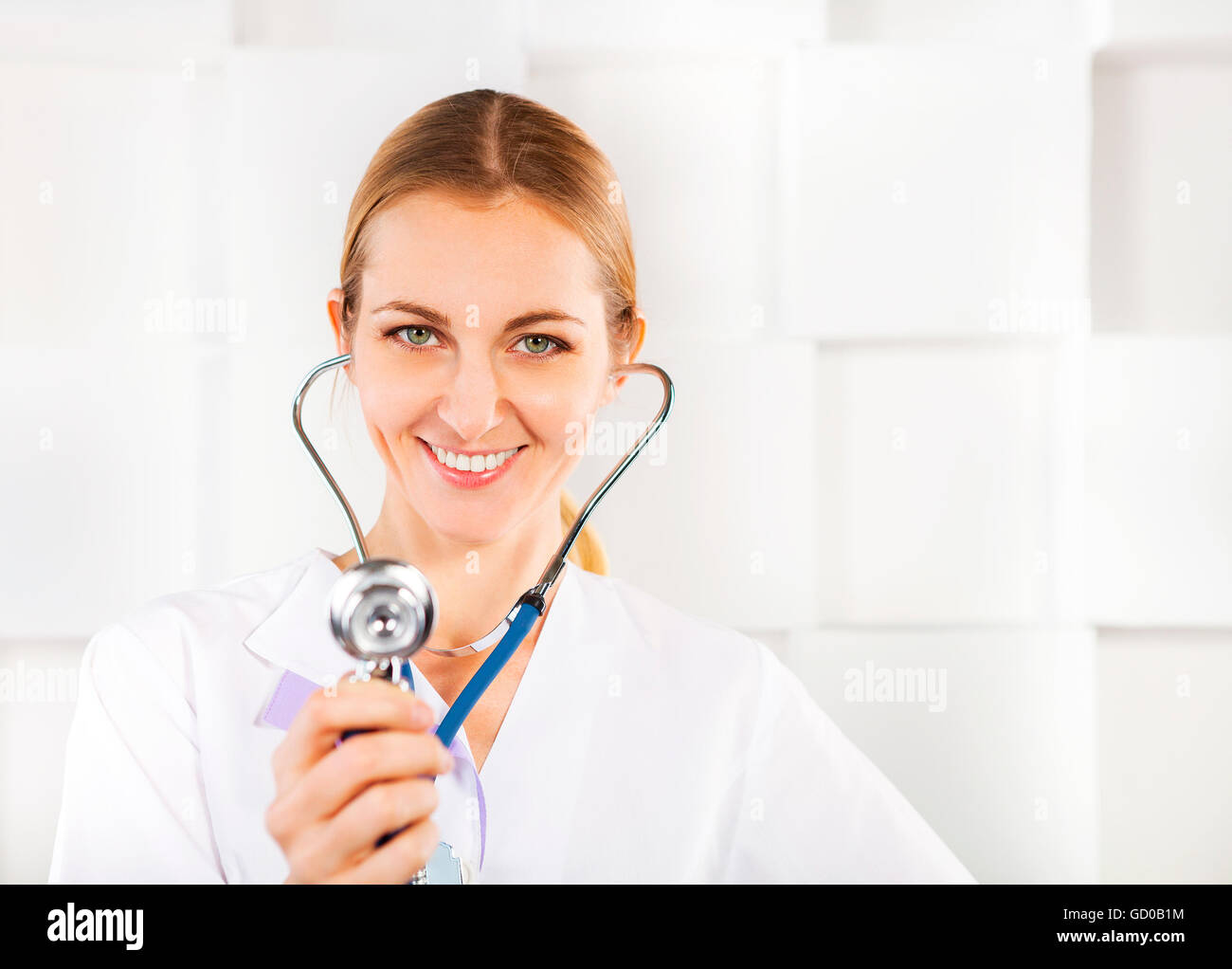 Smiling medical doctor woman listening over white background Stock ...