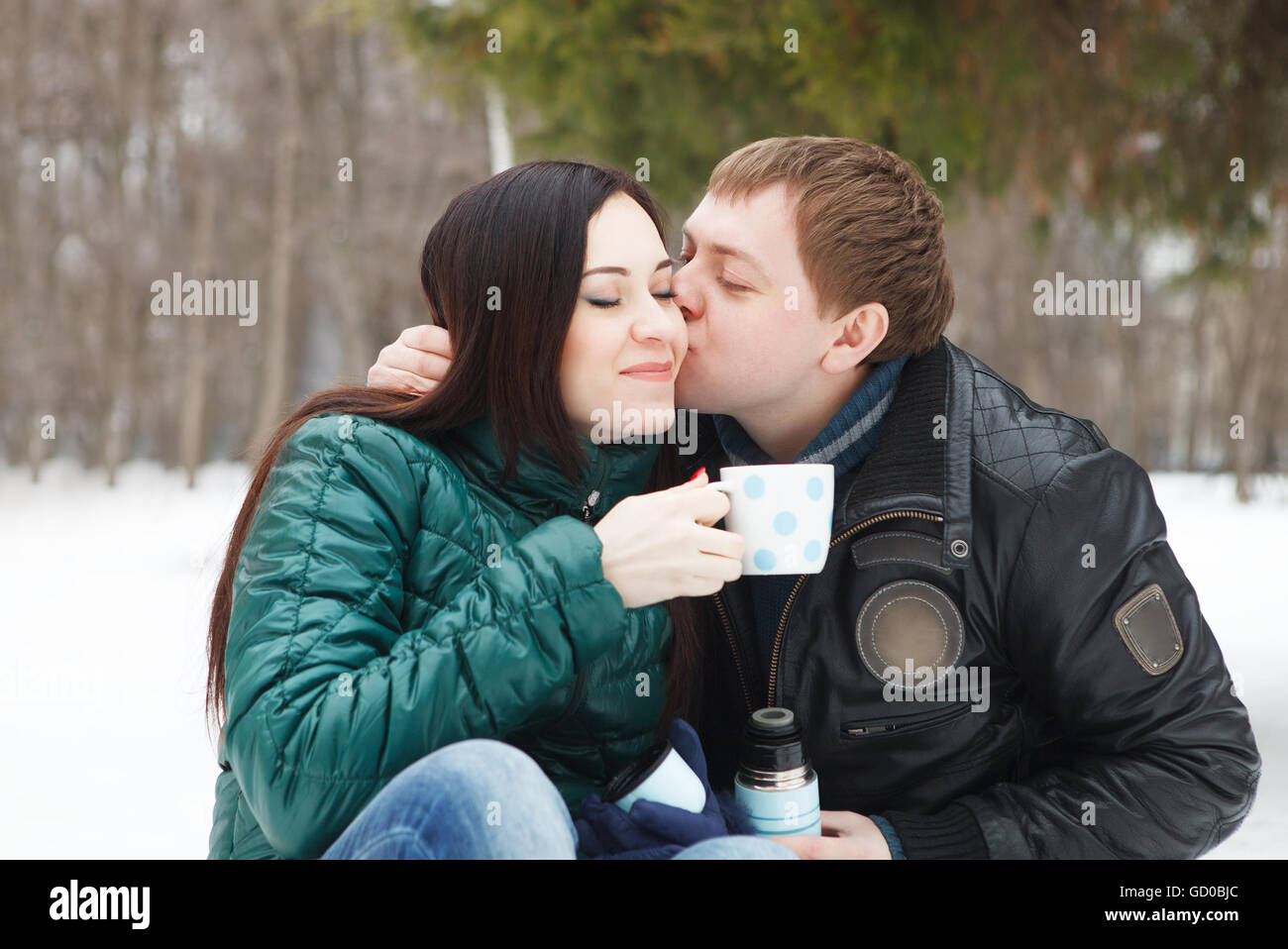 Happy young couple having fun in the winter park Stock Photo - Alamy