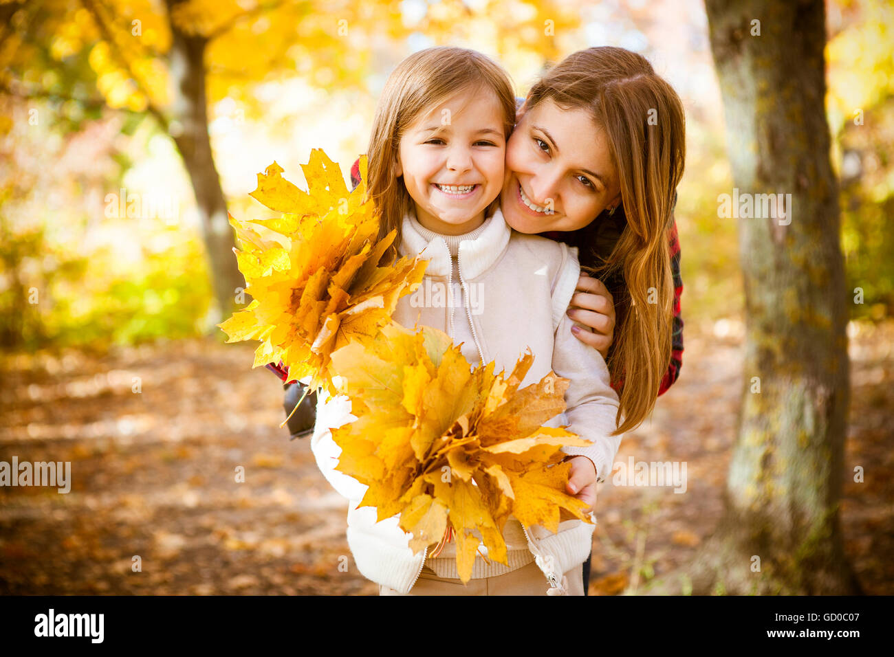 Happy young mother with daughter in autumn park Stock Photo - Alamy