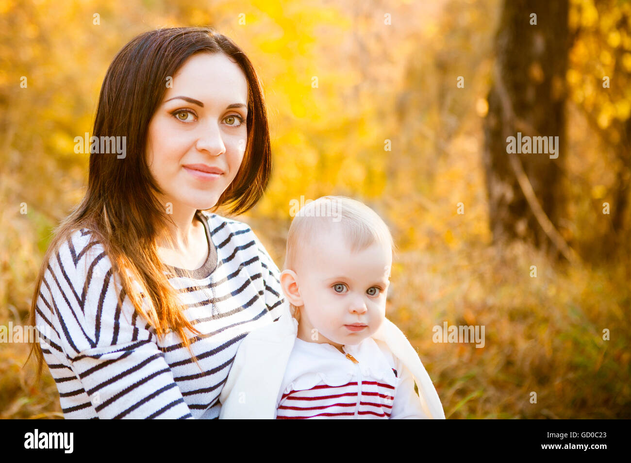 Young mother with her baby daughter in autumn park Stock Photo - Alamy