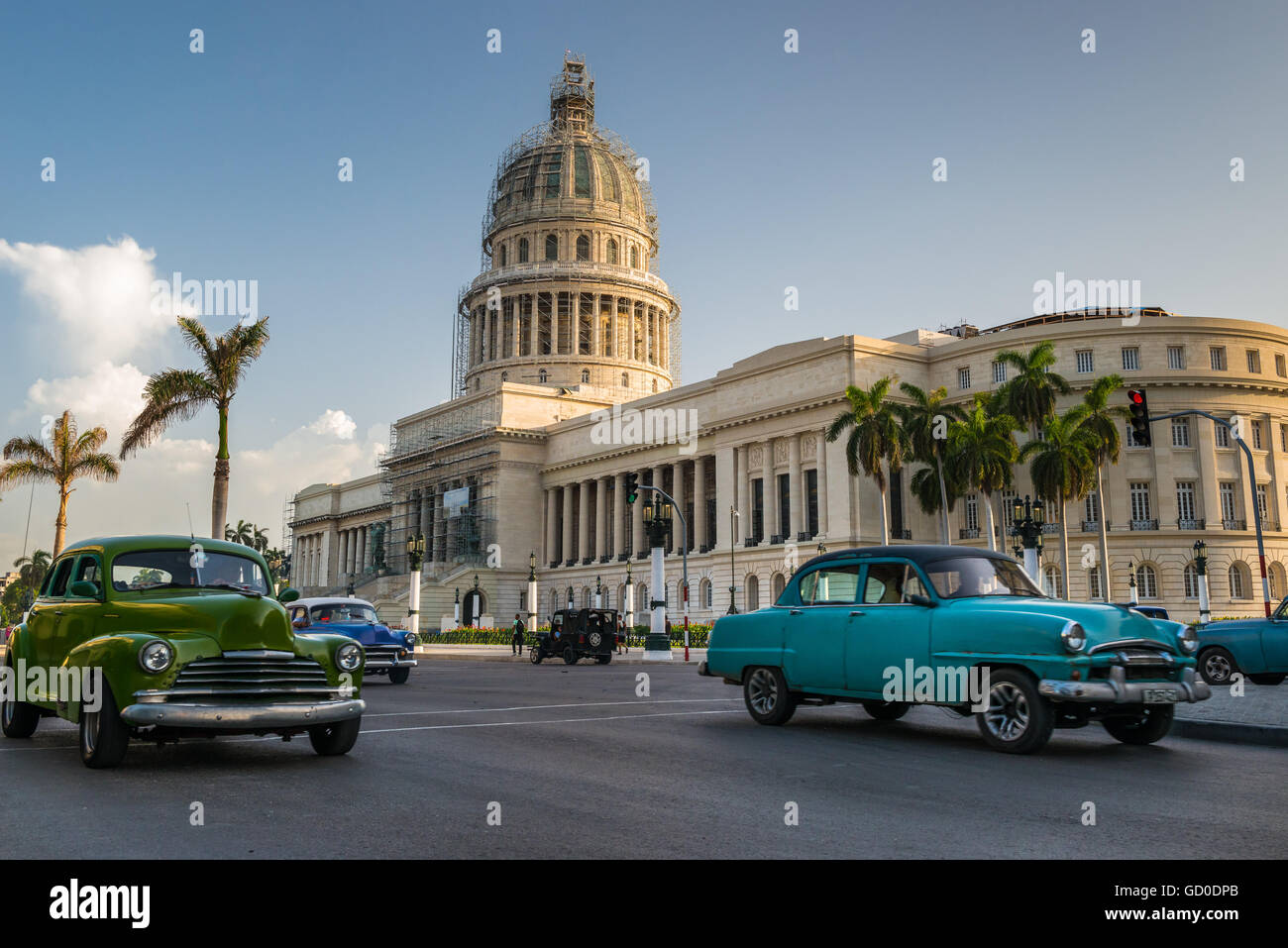 Old American cars drive past the Capitol building in Havana, Cuba. Stock Photo